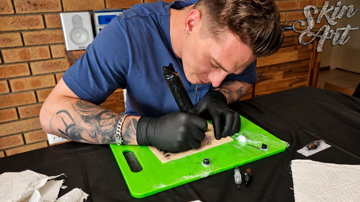 Tattoo trainer demonstrating controlled practice on synthetic skin